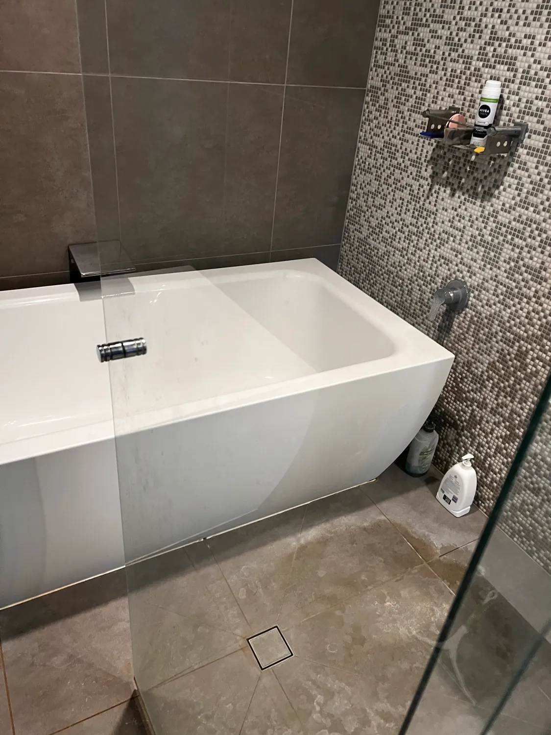 Bathtub with mosaic tiles before cleaning